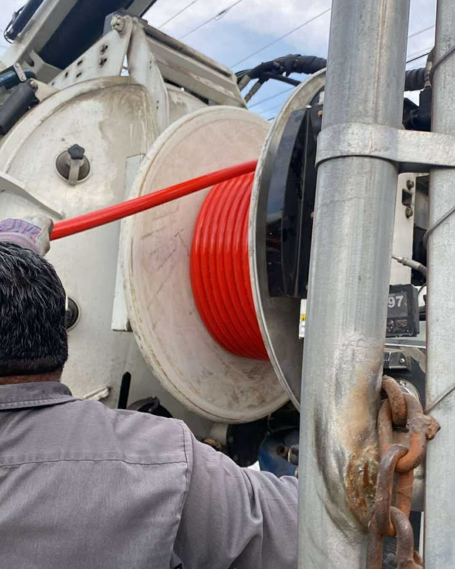Técnico de MAC trabajando con carrete y mangueras en sitio